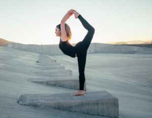 shallow focus photo of woman in black sleeveless shirt doing yoga