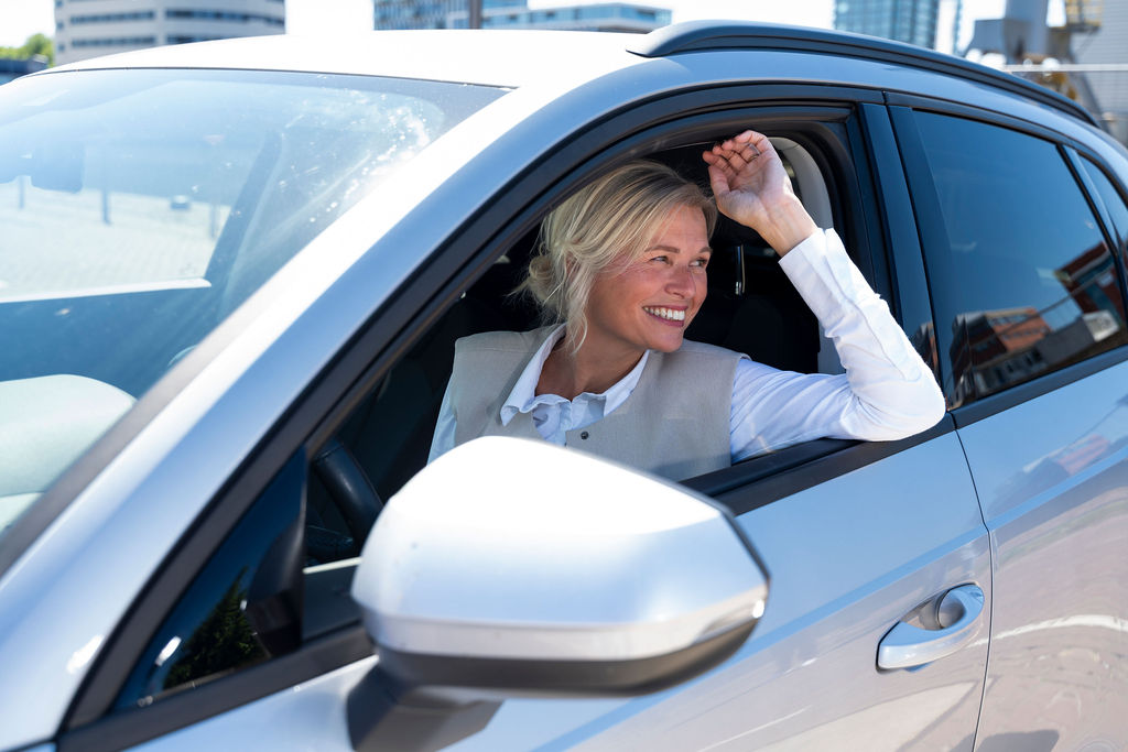 Vrouw in lease auto op zonnige dag