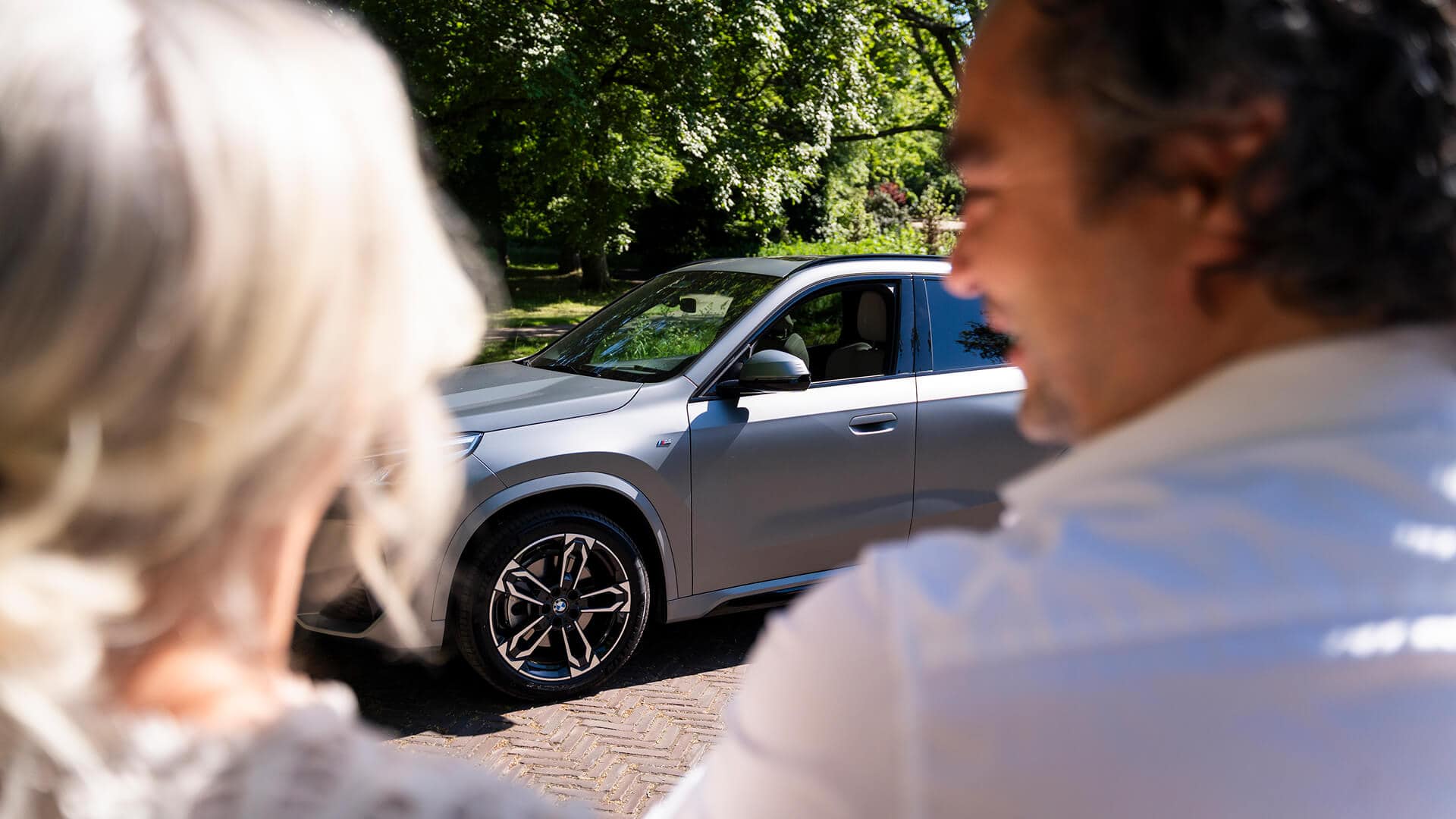 Stel: man en vrrouw bekijken een private lease hybride auto