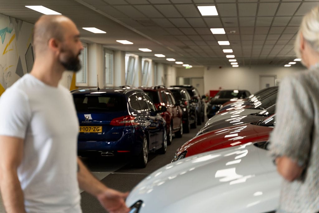 Bezoekers bekijken een showroom met leaseauto’s