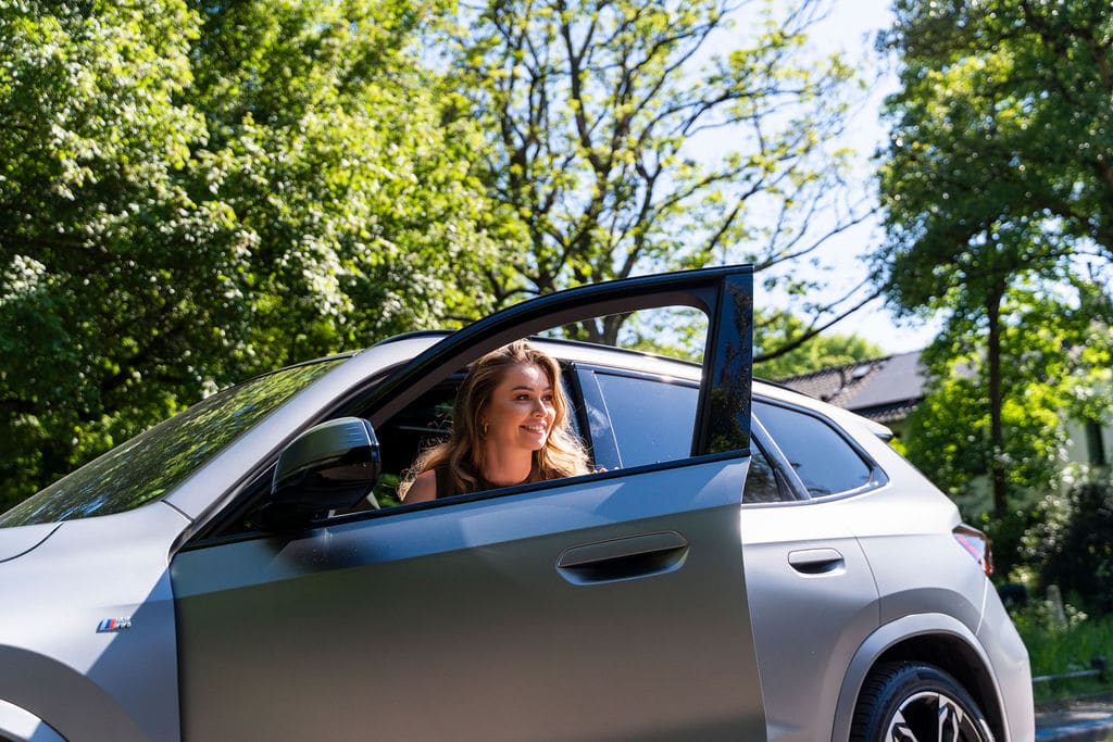 Vrouw stapt lachend uit haar financial lease auto