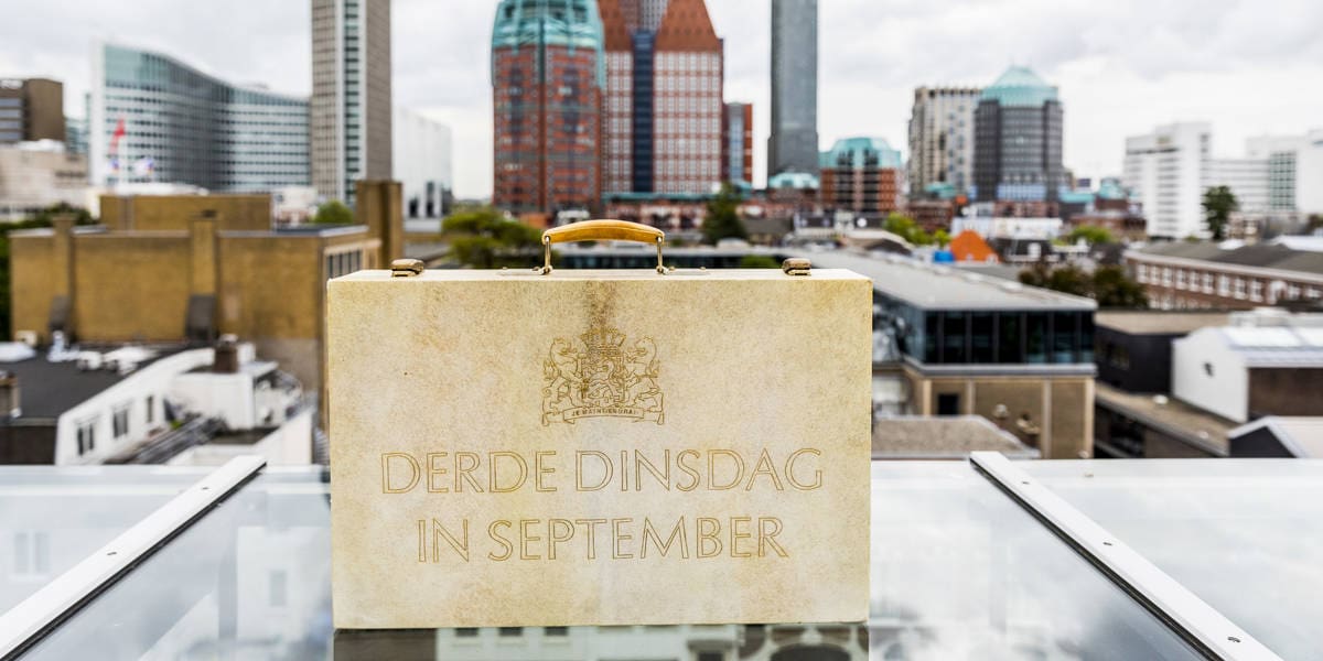 Koffertje van de Miljoenennota met skyline van Den Haag op de achtergrond op Prinsjesdag