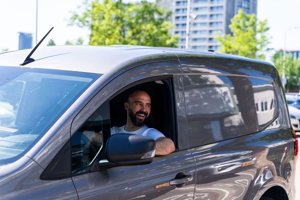 Man in bestelbus met arm uit raam